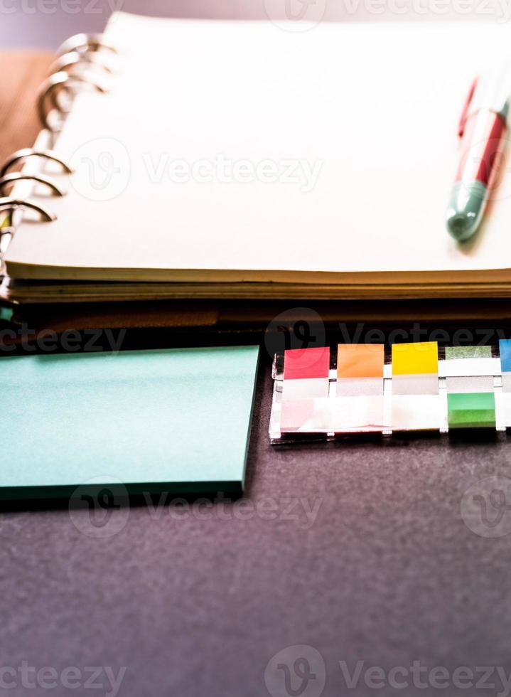 Blank ring binder planner with colorful index tabs and blue note pads use for time management in personal or business. photo