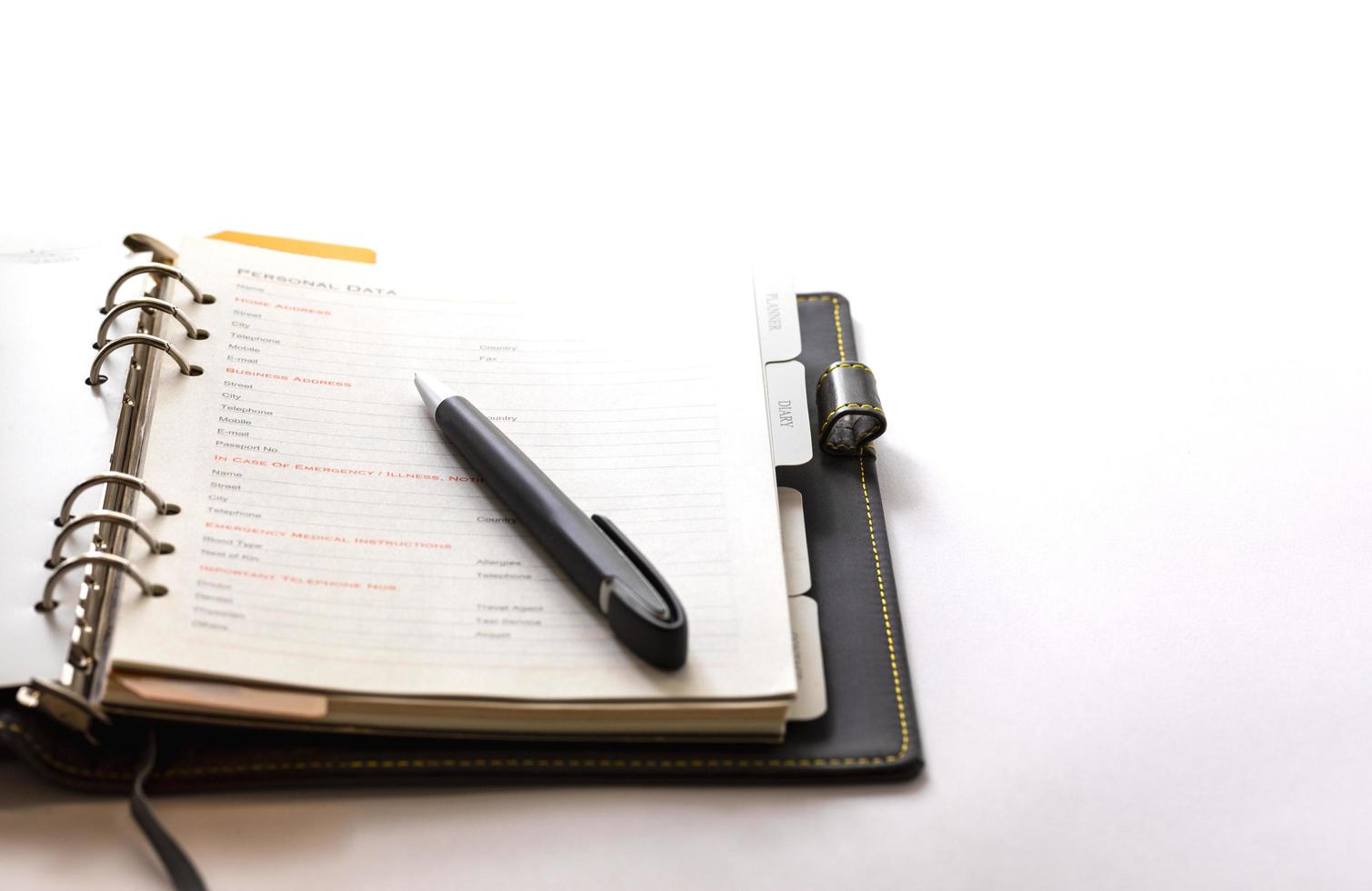 Ring organizer book open on the white background with a black pen photo