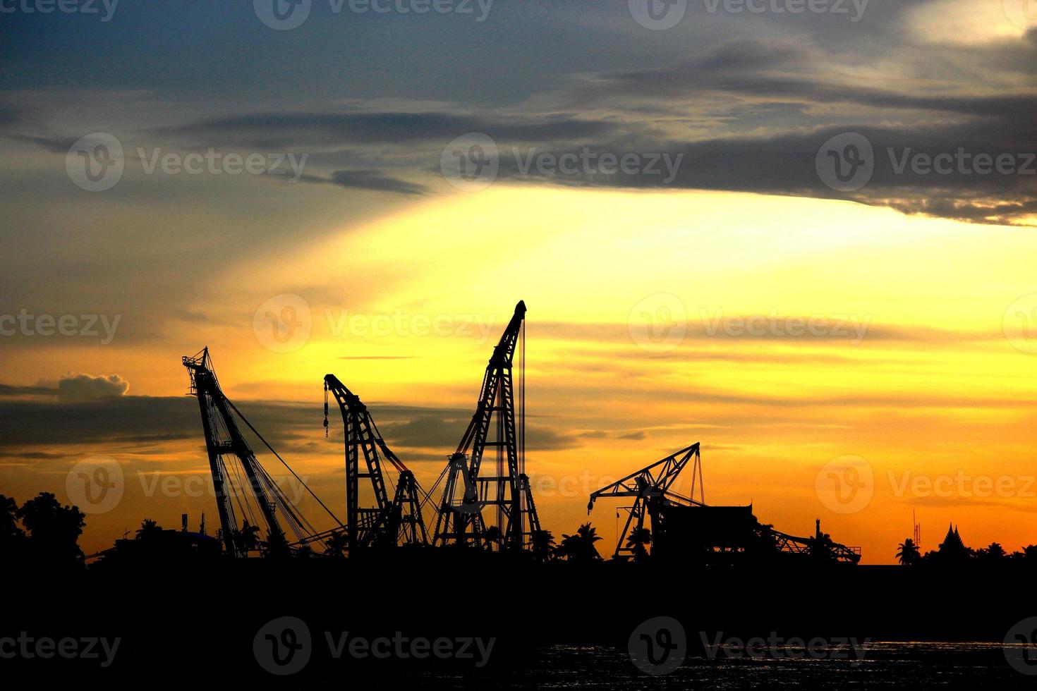 Industrial scene concept of city view. Cranes are working during construction process in sunset. photo