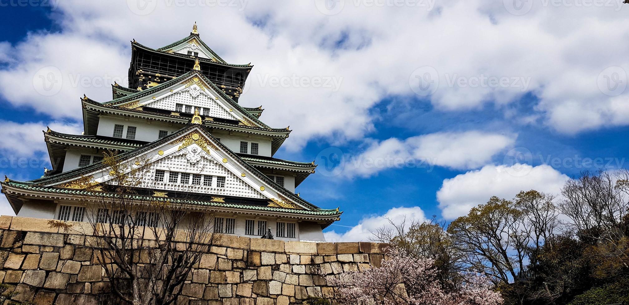 Landscape photo of Osaka Castle in spring, where there are still some cherry blossoms still in bloom.