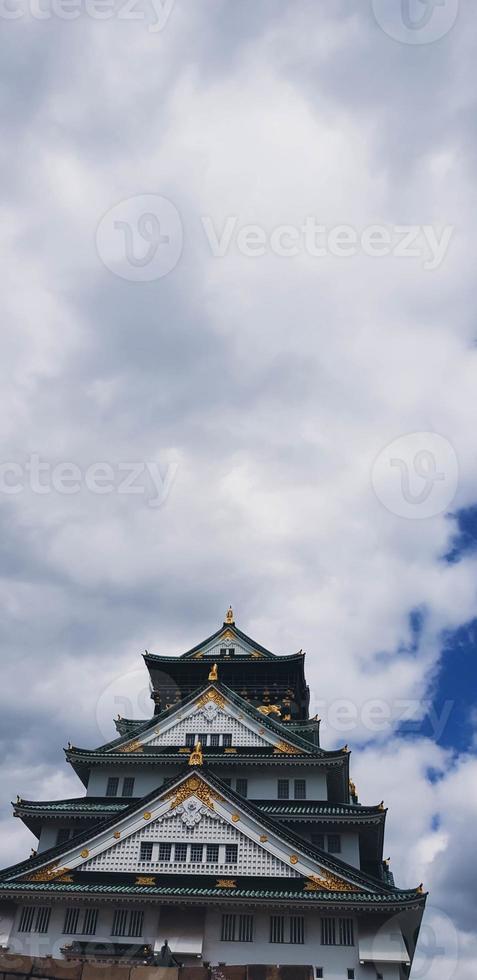 foto paisajística del castillo de osaka en primavera, donde todavía hay algunos cerezos en flor.