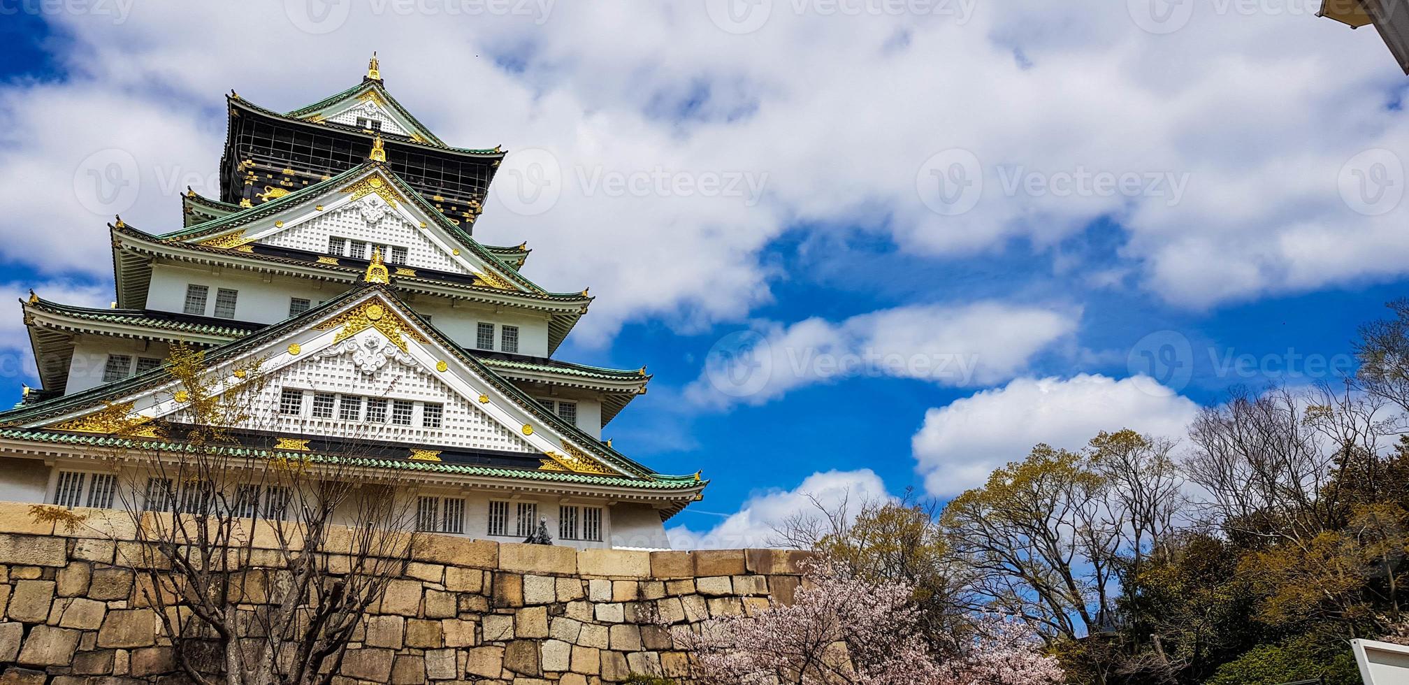 Landscape photo of Osaka Castle in spring, where there are still some cherry blossoms still in bloom.