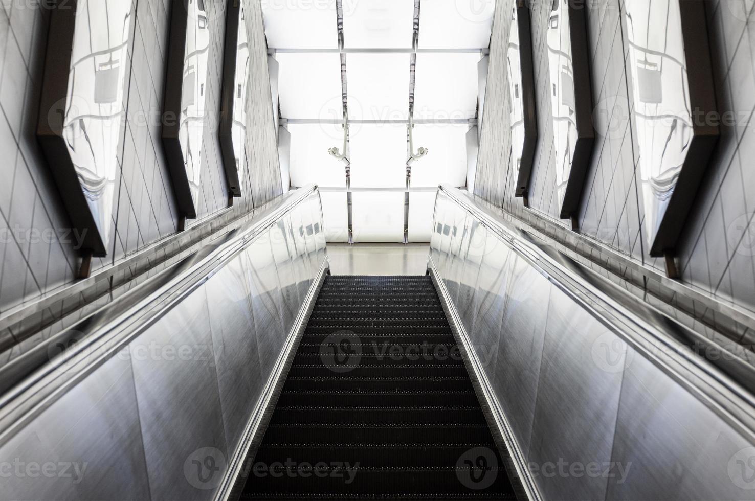Looking up a moving escalator at subway station photo