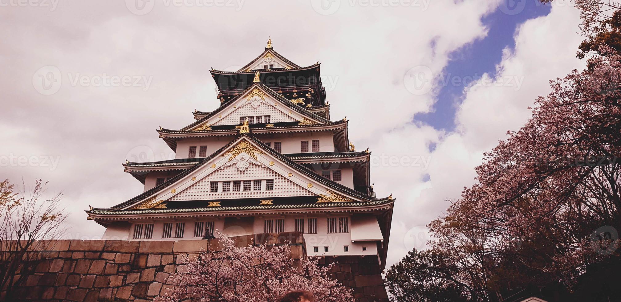 Landscape photo of Osaka Castle in spring, where there are still some cherry blossoms still in bloom.