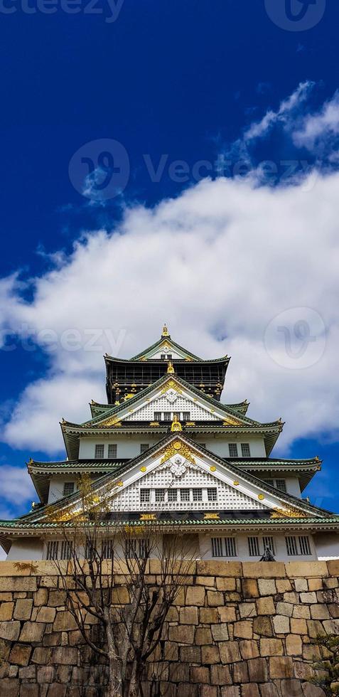 Landscape photo of Osaka Castle in spring, where there are still some cherry blossoms still in bloom.