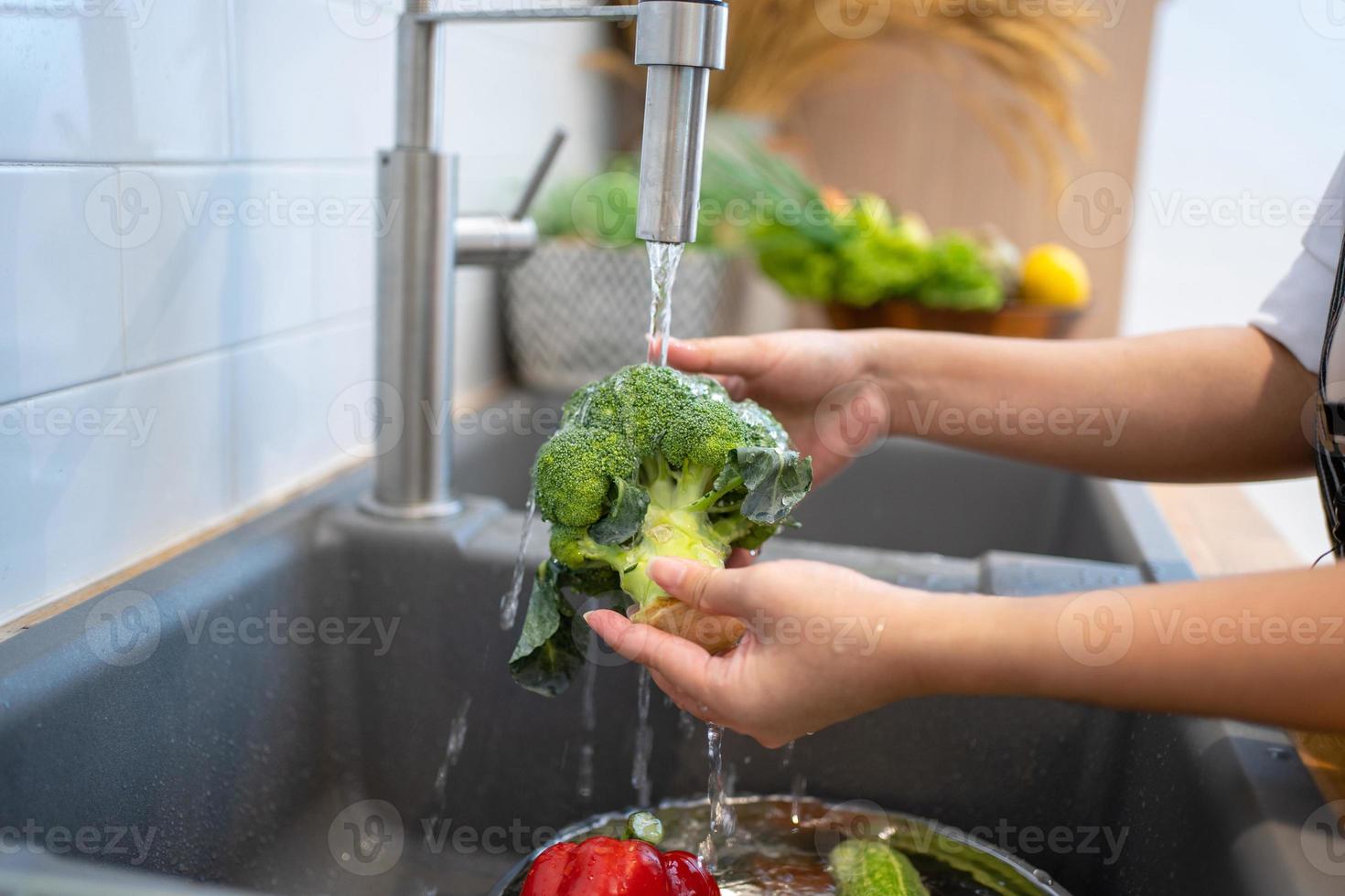 People washing vegetables in the kitchen. photo