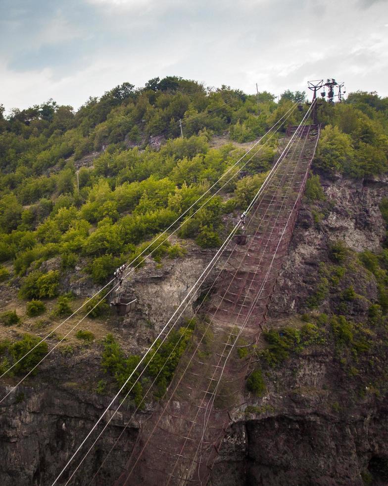 Aeria view ropeway empty bucket above road in Mining area in Chiatura. Transporting container. Sunset over industry cranes and cable railway. Transportation and mining Industry photo