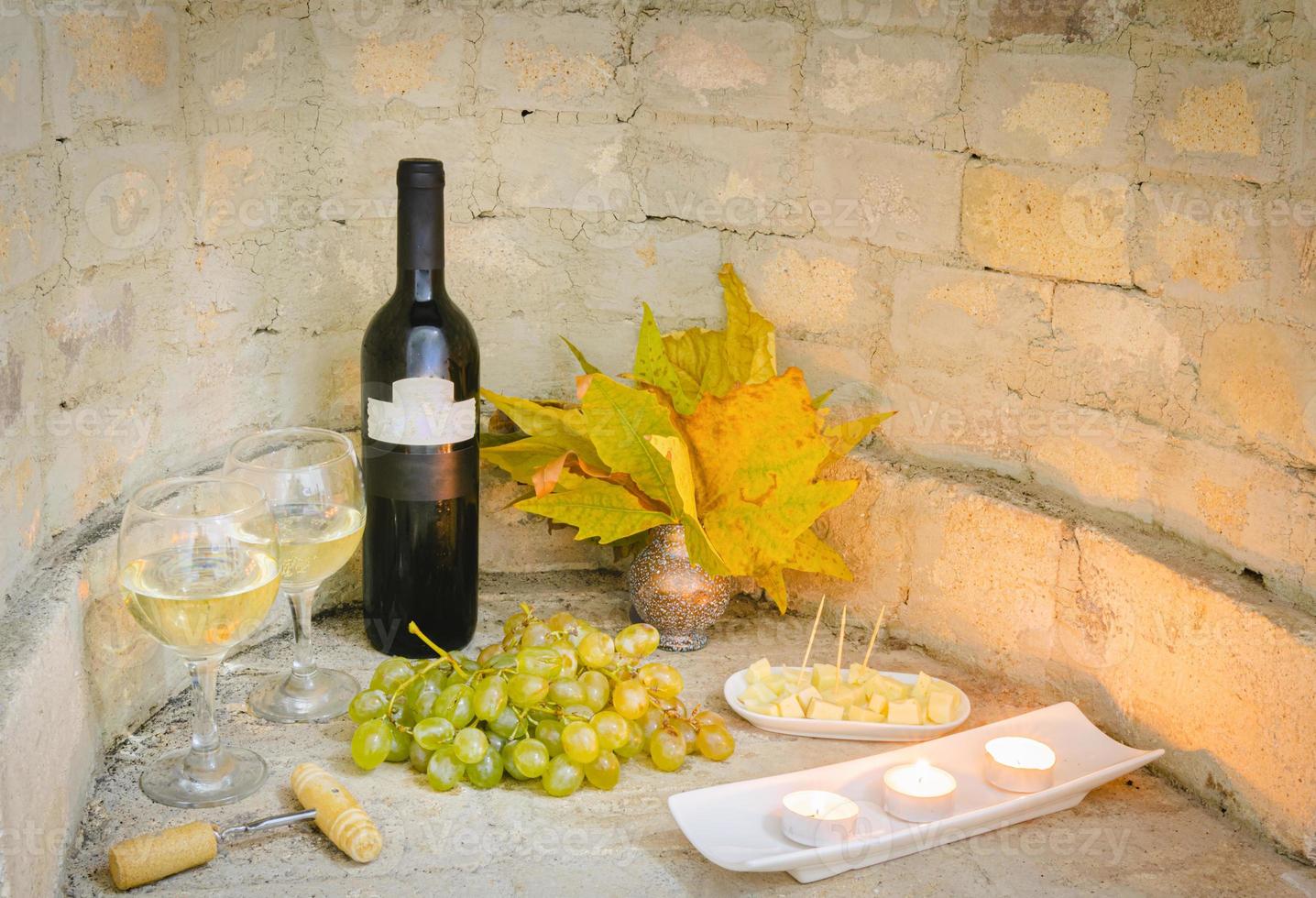 Bottle of wine by candles and cheese in autumn photo