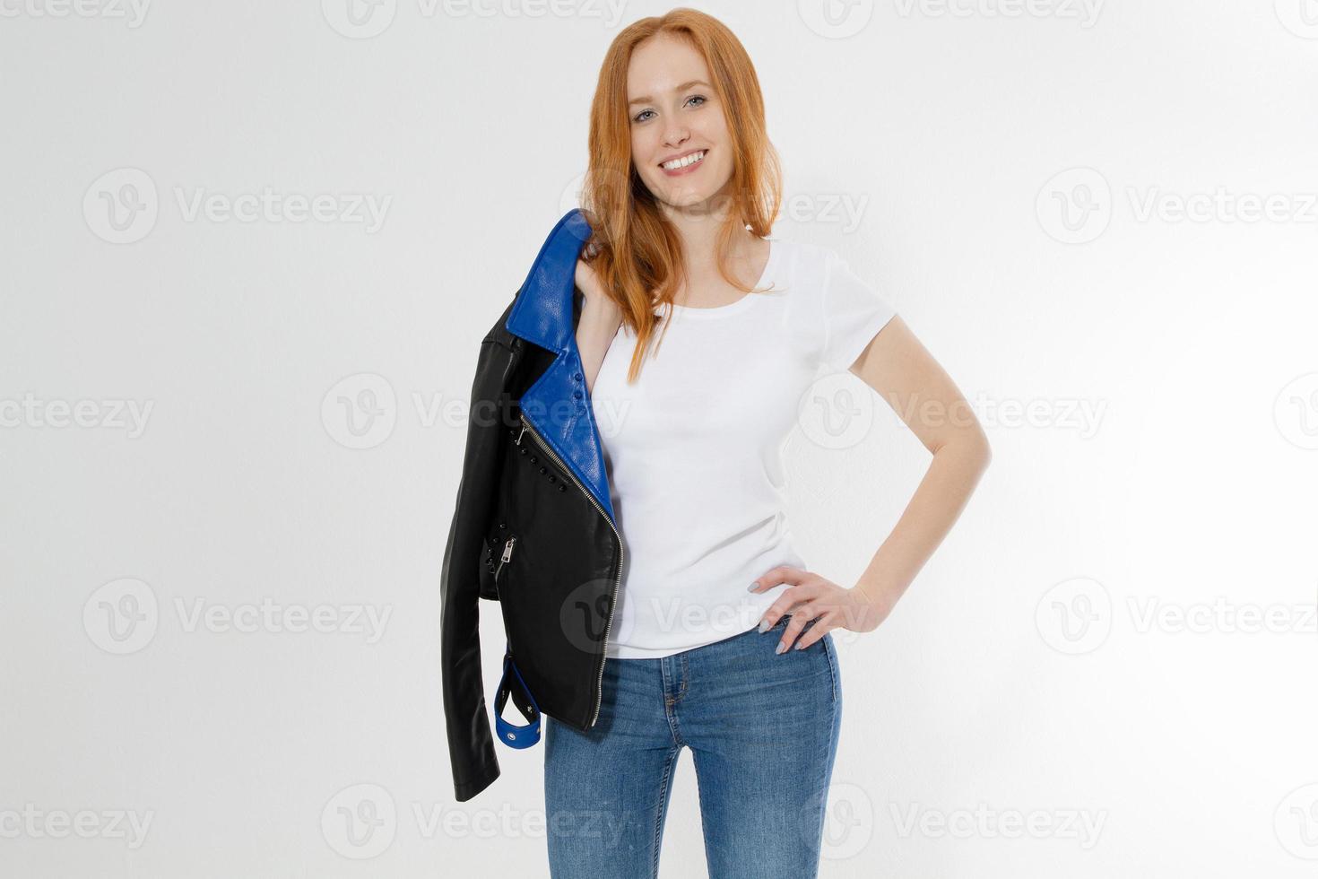 Woman in white t shirt and black leather jacket isolated on white background. Red hair girl in fashion clothes front view. Blank template summer t-shirt. Copy space photo
