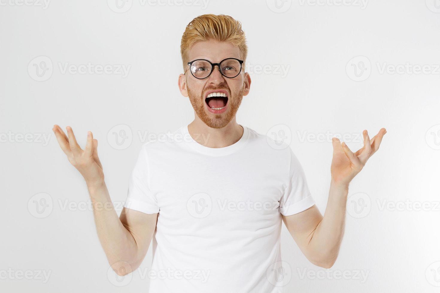 Man Depression signs and Symptoms. Young redheaded guy with red beard and white t shirt shouting hard and angry. Failed startup and fail exam concept. Unhappy businessman with aggressive feelings. photo