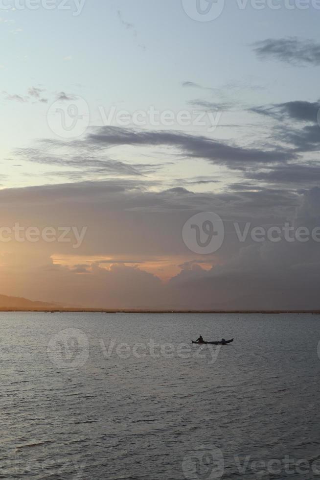 silueta de pescador en su barco foto