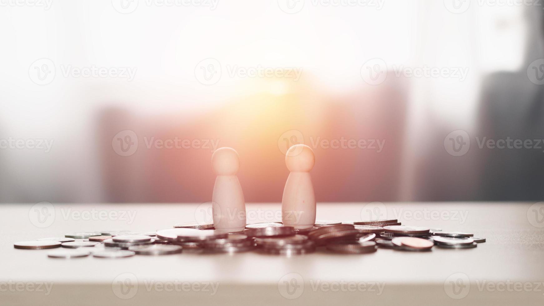 Business contact and financial concept. Two wooden figures standing on piles of coins, business negotiations, trading dealings, brokers. photo