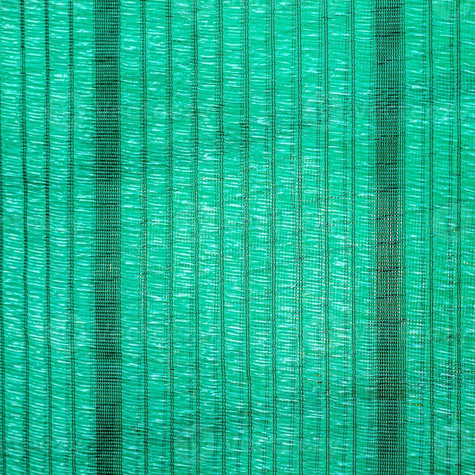 Green shading net surface for protection from sunlight, there is a hole for the wind to pass through for use in agriculture. photo