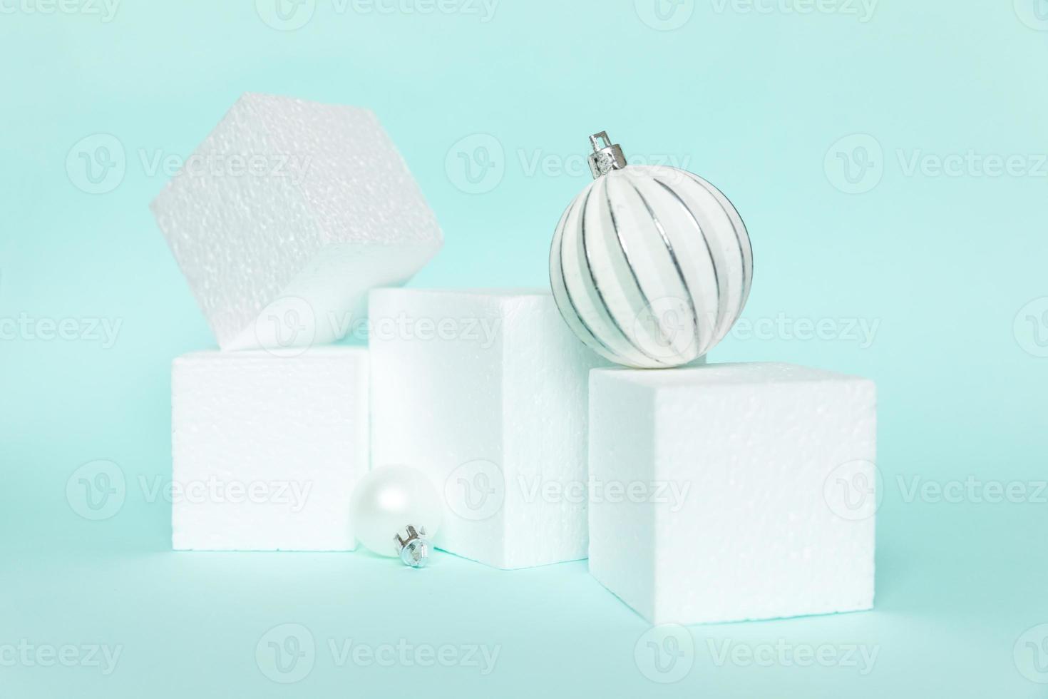 Simply minimal composition winter objects ornament and cube shapes geometric form podium isolated blue pastel background. Christmas New Year december time for celebration concept. Mockup, copy space photo