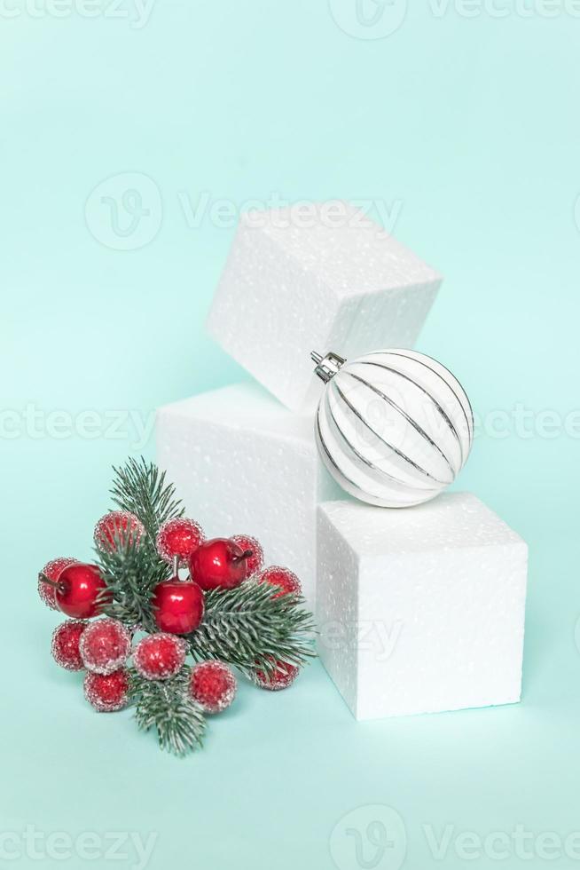 Simply minimal composition winter objects ornament and cube shapes geometric form podium isolated blue pastel background. Christmas New Year december time for celebration concept. Mockup, copy space photo