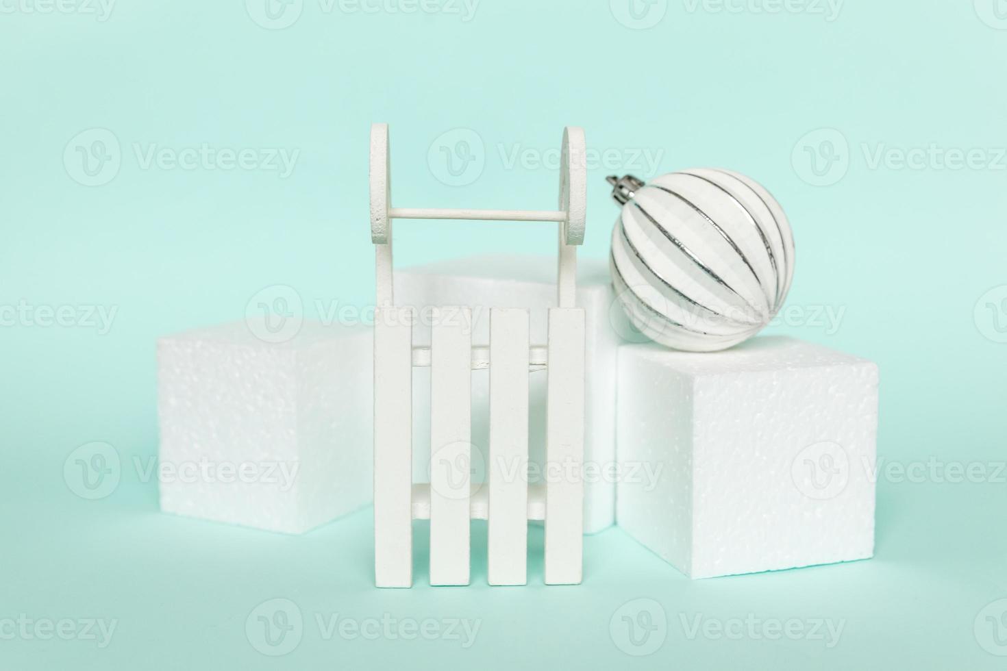 Simply minimal composition winter objects ornament and cube shapes geometric form podium isolated blue pastel background. Christmas New Year december time for celebration concept. Mockup, copy space photo