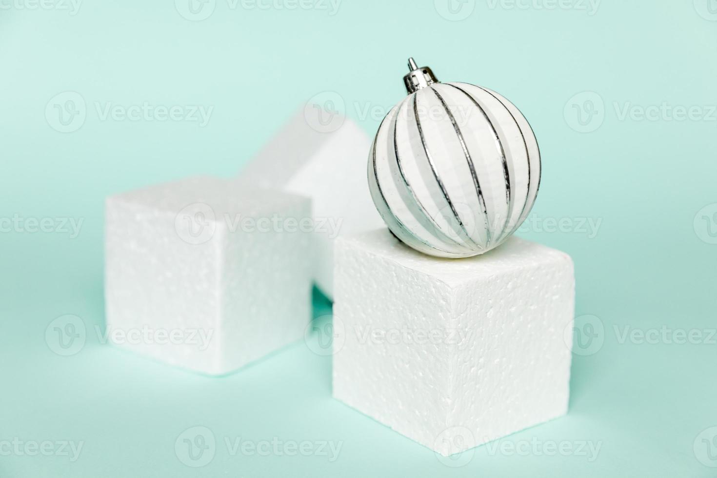 Simply minimal composition winter objects ornament and cube shapes geometric form podium isolated blue pastel background. Christmas New Year december time for celebration concept. Mockup, copy space photo