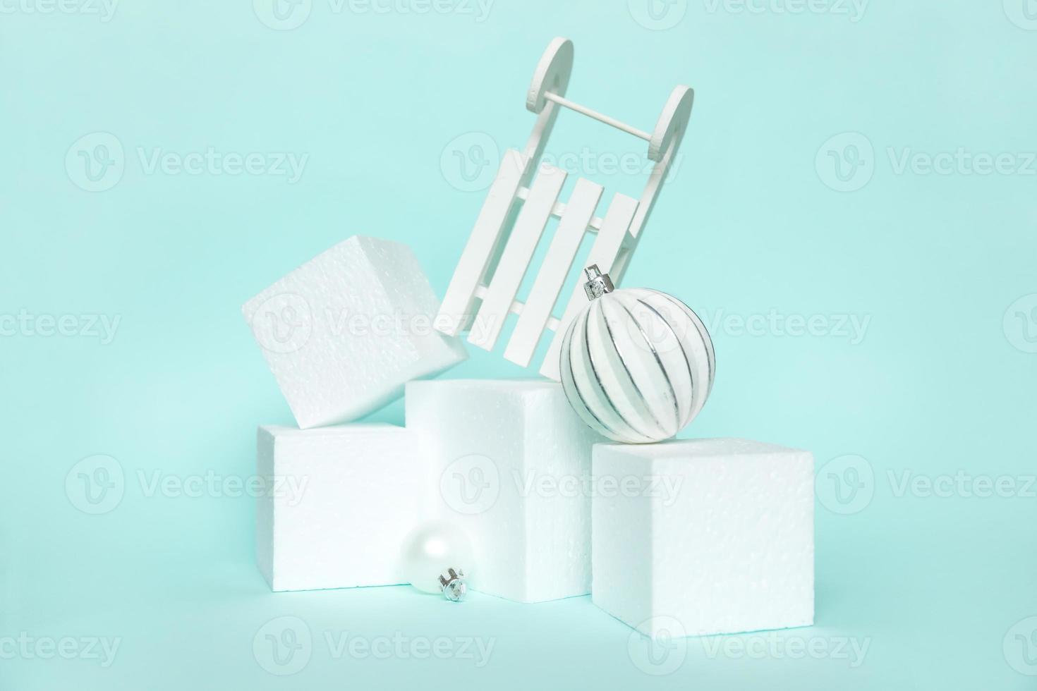 Simply minimal composition winter objects ornament and cube shapes geometric form podium isolated blue pastel background. Christmas New Year december time for celebration concept. Mockup, copy space photo