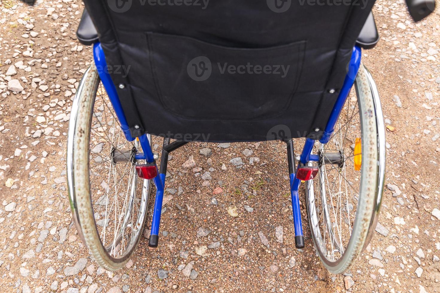 silla de ruedas vacía parada en la carretera esperando servicios para pacientes. silla de ruedas para personas con discapacidad estacionada al aire libre. accesible para persona con discapacidad. concepto médico de atención médica. foto