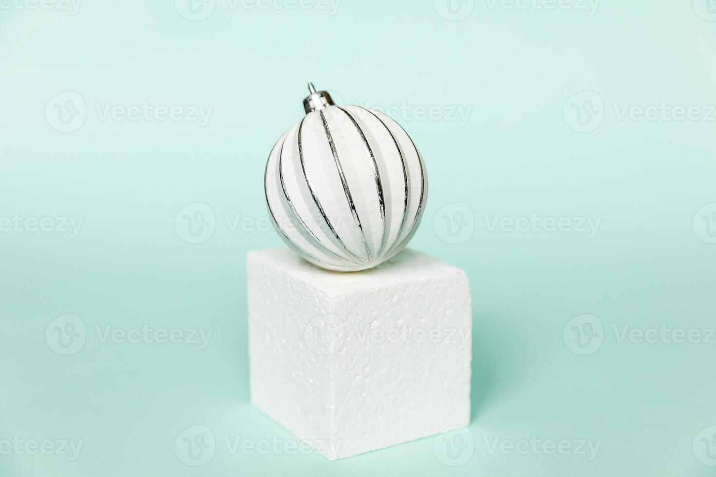Simply minimal composition winter objects ornament and cube shapes geometric form podium isolated blue pastel background. Christmas New Year december time for celebration concept. Mockup, copy space photo
