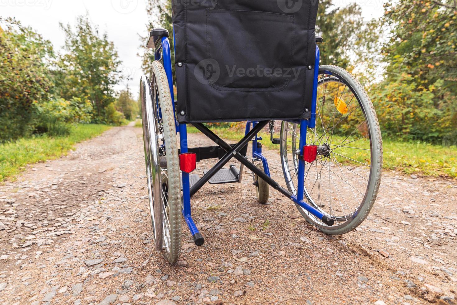 silla de ruedas vacía parada en la carretera esperando servicios para pacientes. silla de ruedas para personas con discapacidad estacionada al aire libre. accesible para persona con discapacidad. concepto médico de atención médica. foto