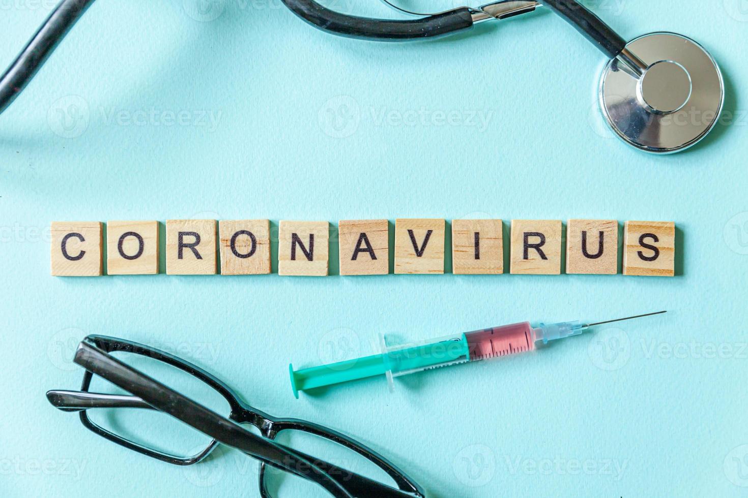 Text phrase Coronavirus syringe eyeglasses and stethoscope on blue pastel background. Novel coronavirus 2019-nCoV MERS-Cov covid-19 middle East respiratory syndrome coronavirus virus vaccine concept. photo