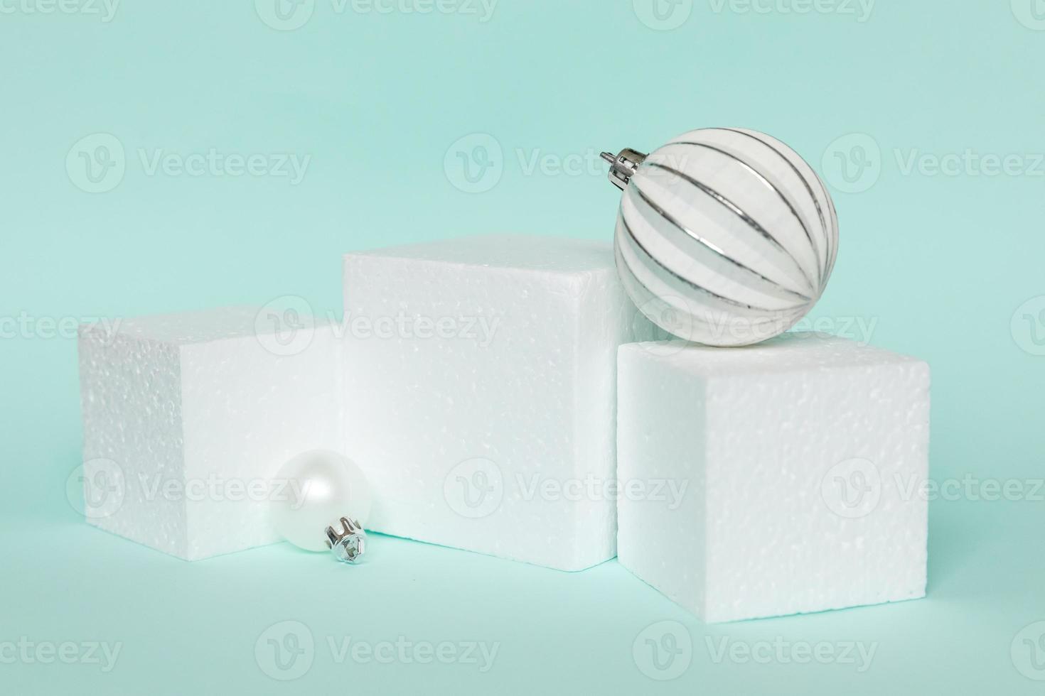 Simply minimal composition winter objects ornament and cube shapes geometric form podium isolated blue pastel background. Christmas New Year december time for celebration concept. Mockup, copy space photo