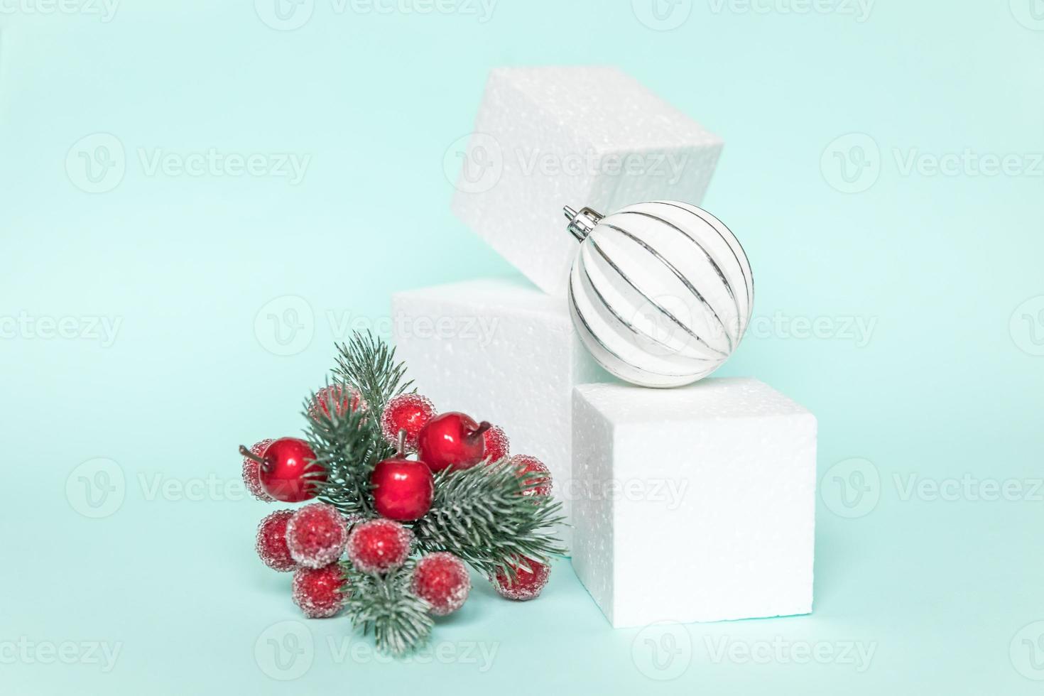 Simply minimal composition winter objects ornament and cube shapes geometric form podium isolated blue pastel background. Christmas New Year december time for celebration concept. Mockup, copy space photo