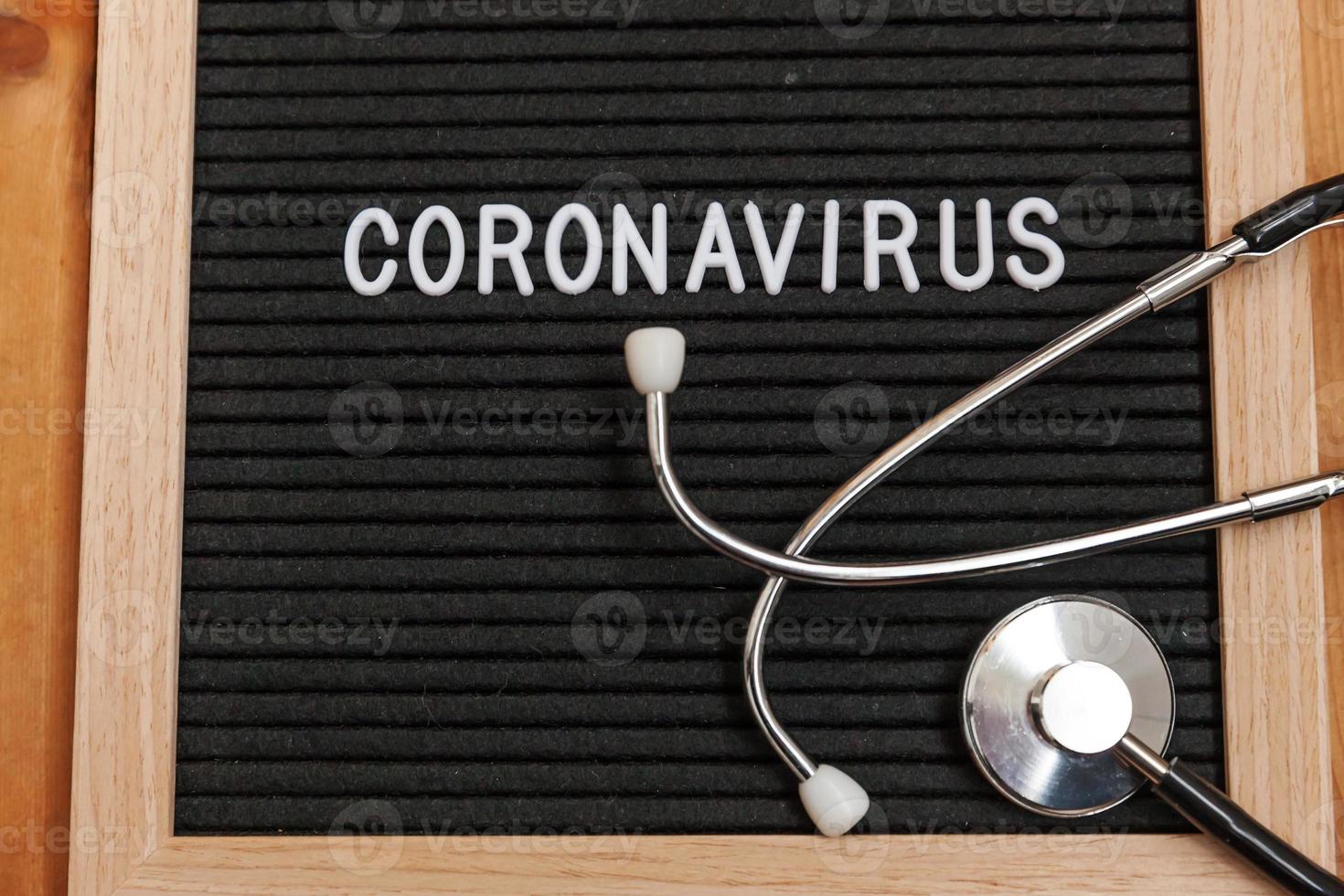 frase de texto coronavirus y estetoscopio sobre fondo de tablero de letras negras. nuevo coronavirus 2019-ncov, mers-cov síndrome respiratorio de oriente medio coronavirus originario de wuhan china foto