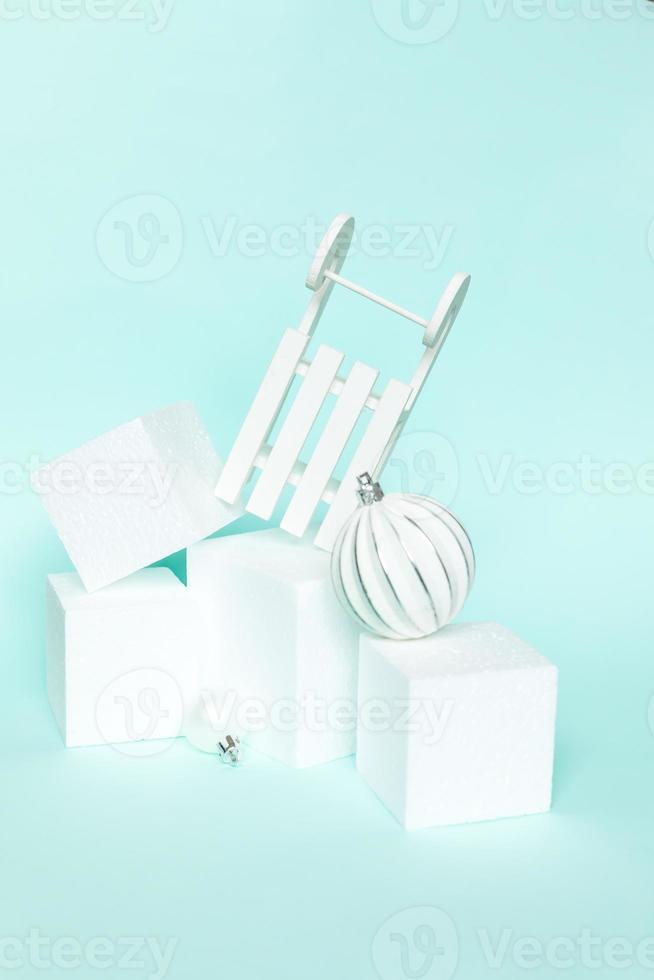 Simply minimal composition winter objects ornament and cube shapes geometric form podium isolated blue pastel background. Christmas New Year december time for celebration concept. Mockup, copy space photo