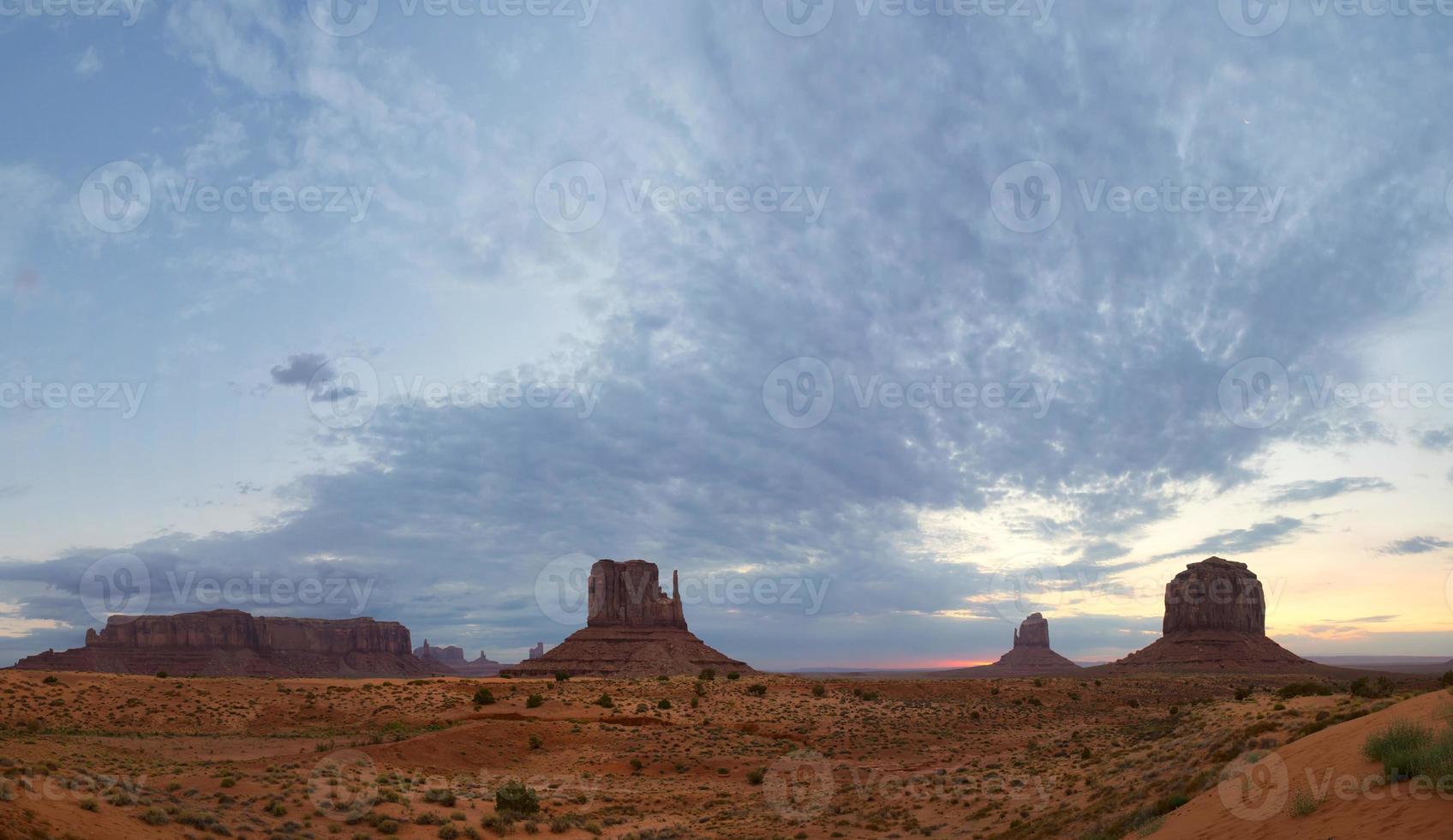 Monument Valley view at sunset with wonderfull cloudy sky and lights on mittens photo