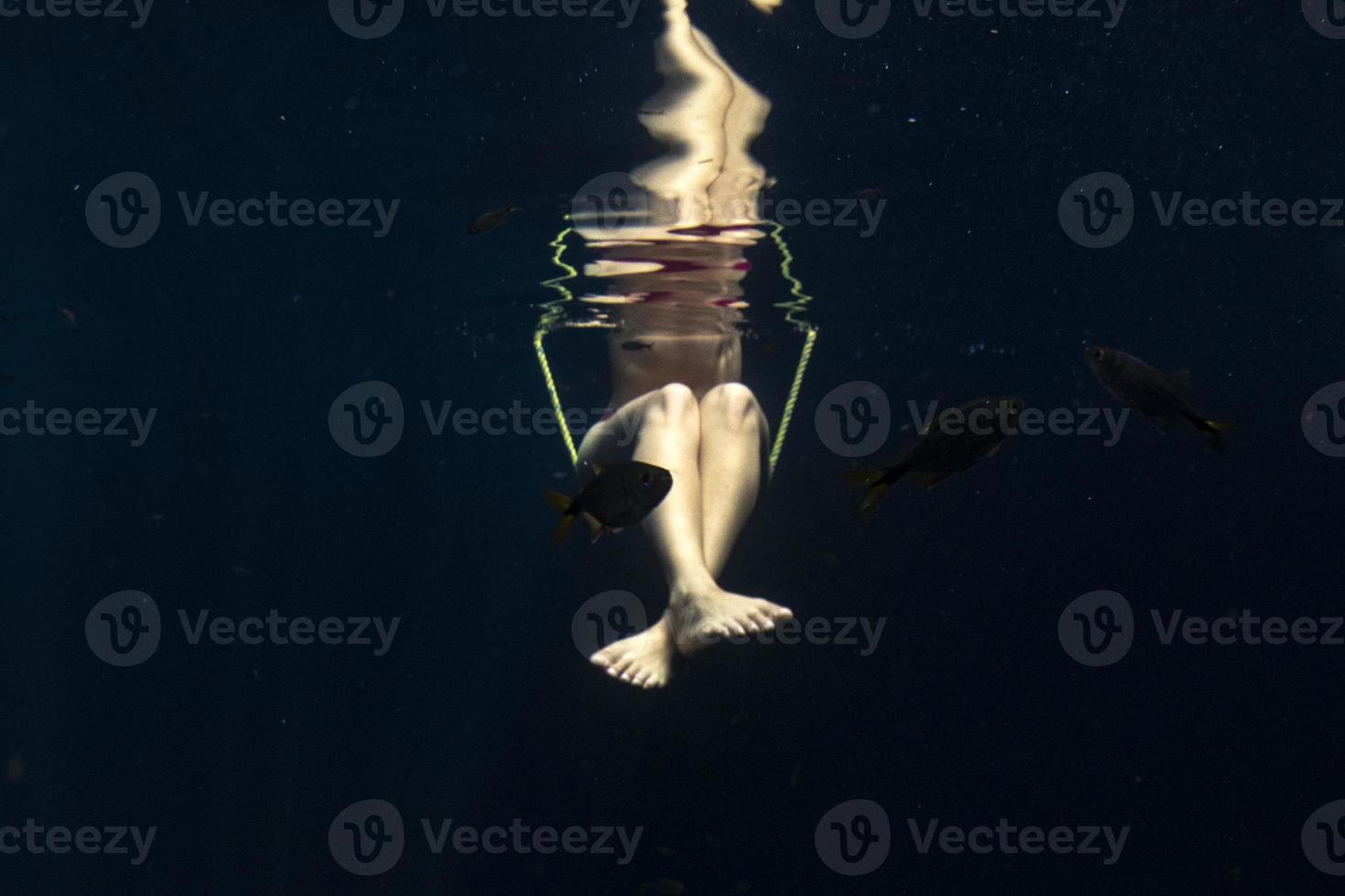 beautiful legs woman underwater on teeter totter swing photo