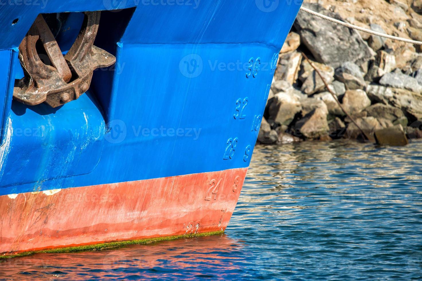 ancla robusta oxidada en un barco de pesca azul foto