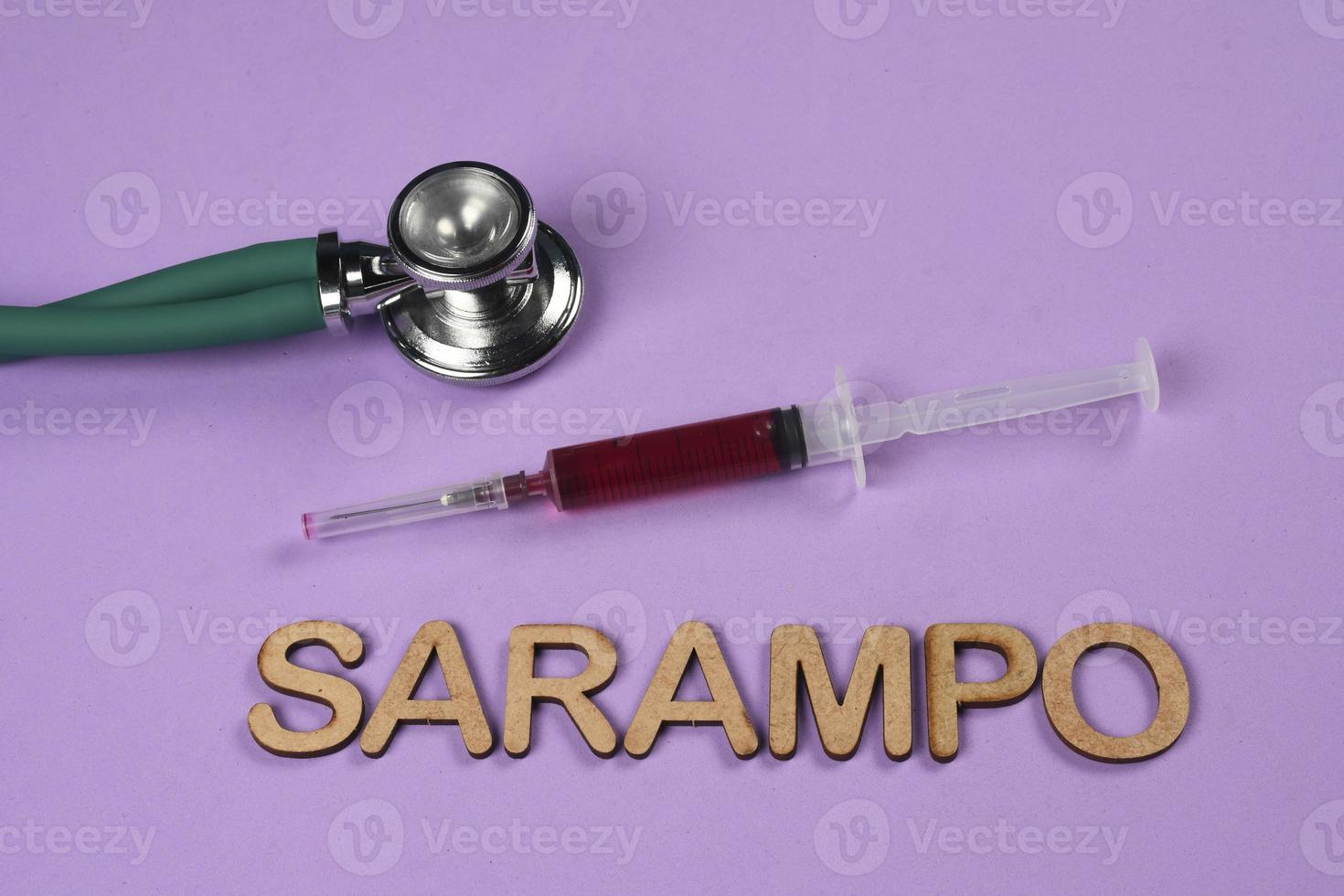 Vaccination syringe with the word measles written in Portuguese. photo