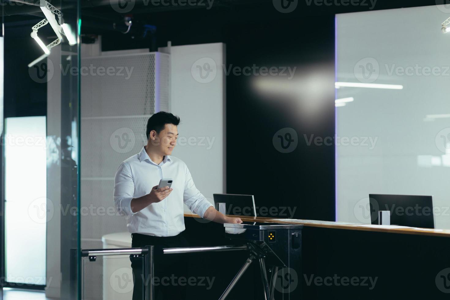 Asian worker enters the office through the door, opens the lock with a plastic card photo