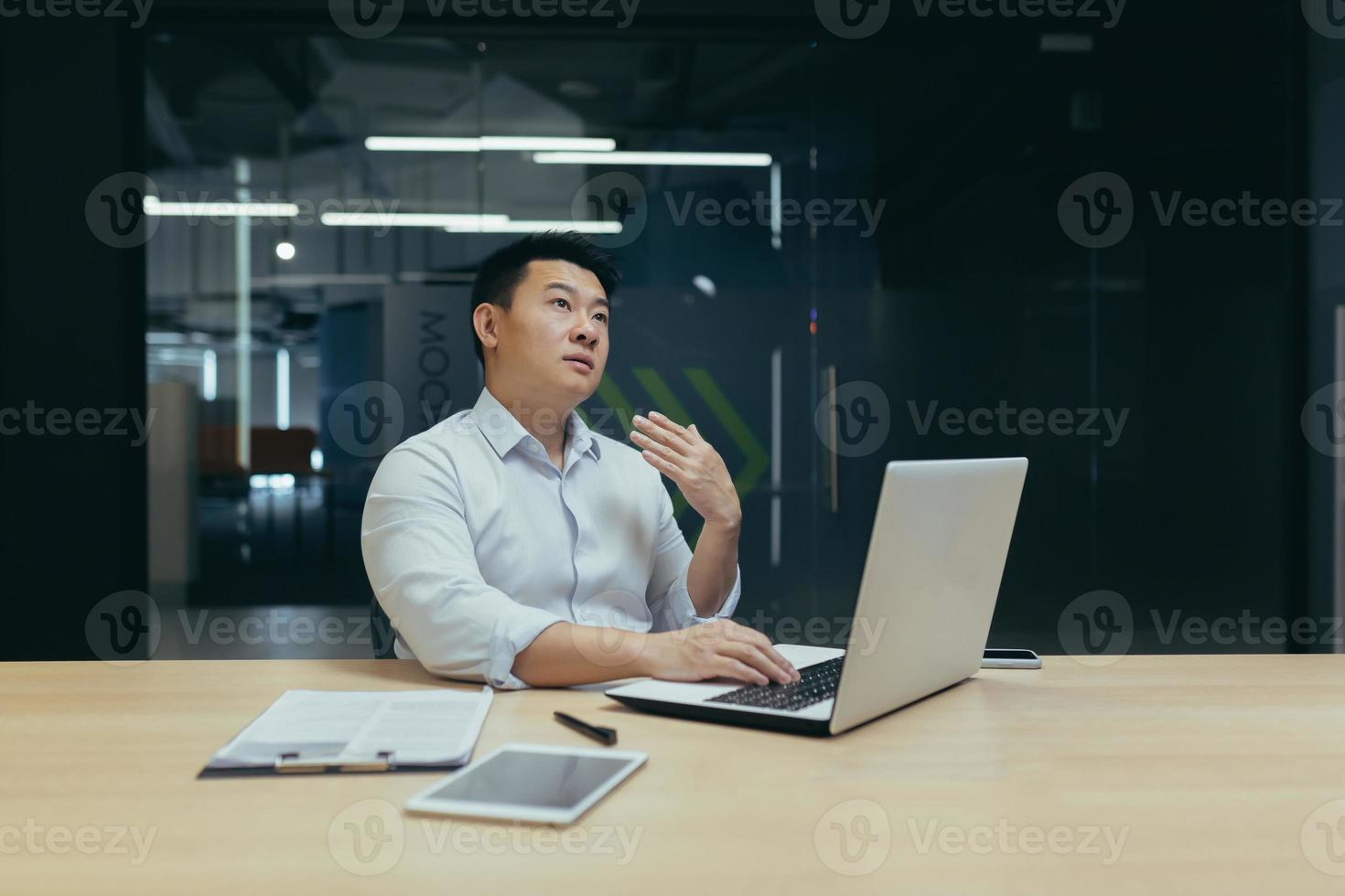 Young man Asian businessman not feeling well at work. He waves his hand, he's short of breath photo