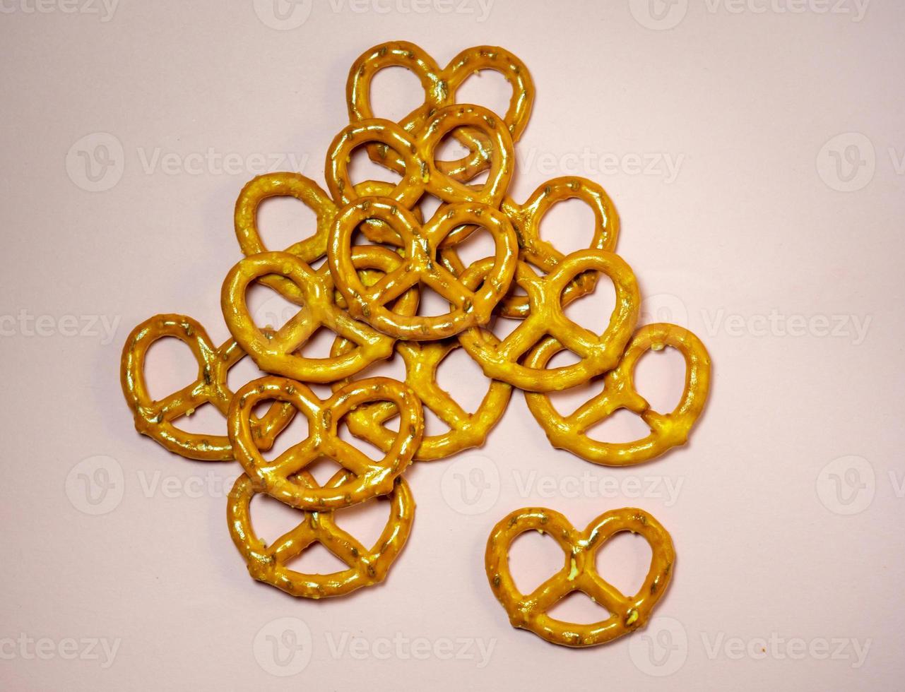 Small pretzels on a pink background. Flour product. A delicacy for tea. Wicker crispy biscuits. photo