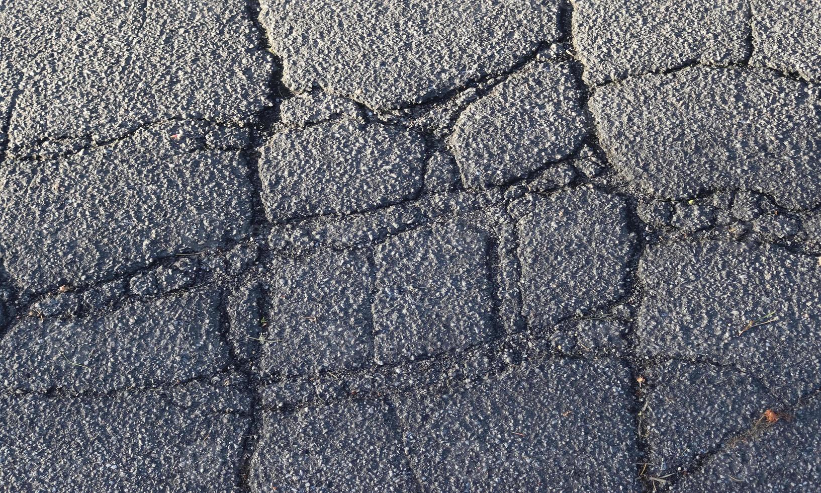 Detailed view on asphalt surfaces of different streets and roads with cracks photo