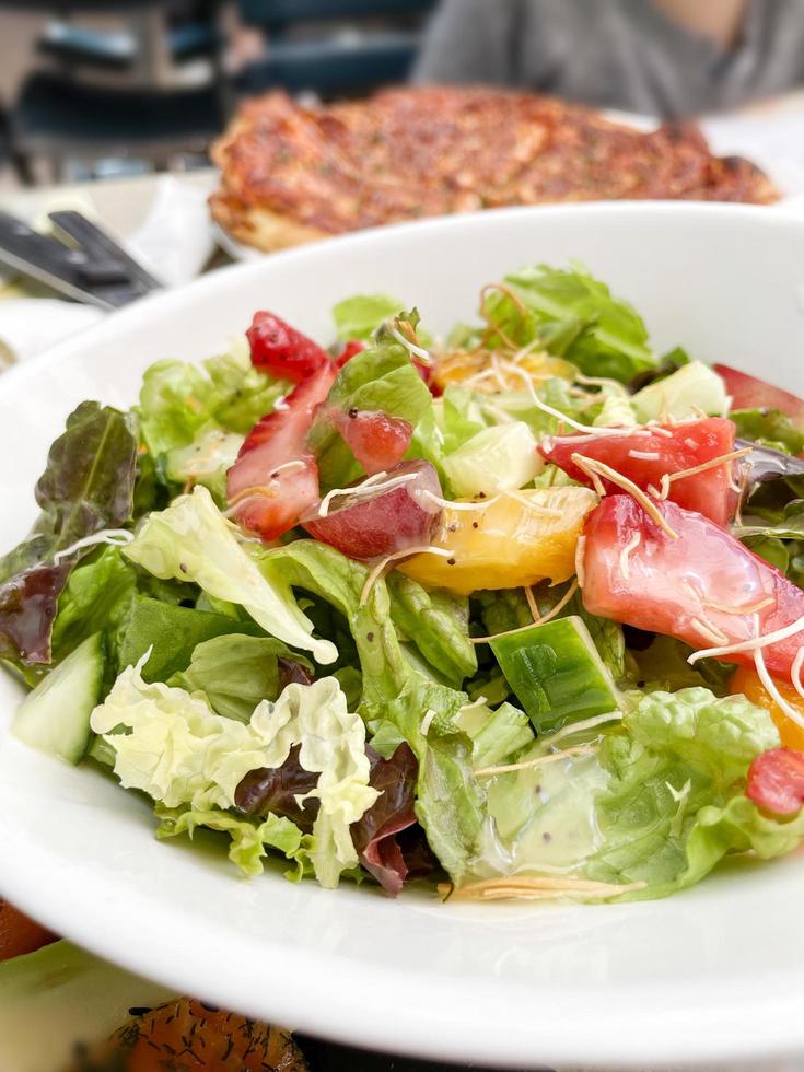 Salad with strawberries mango and grapes at a restaurant photo