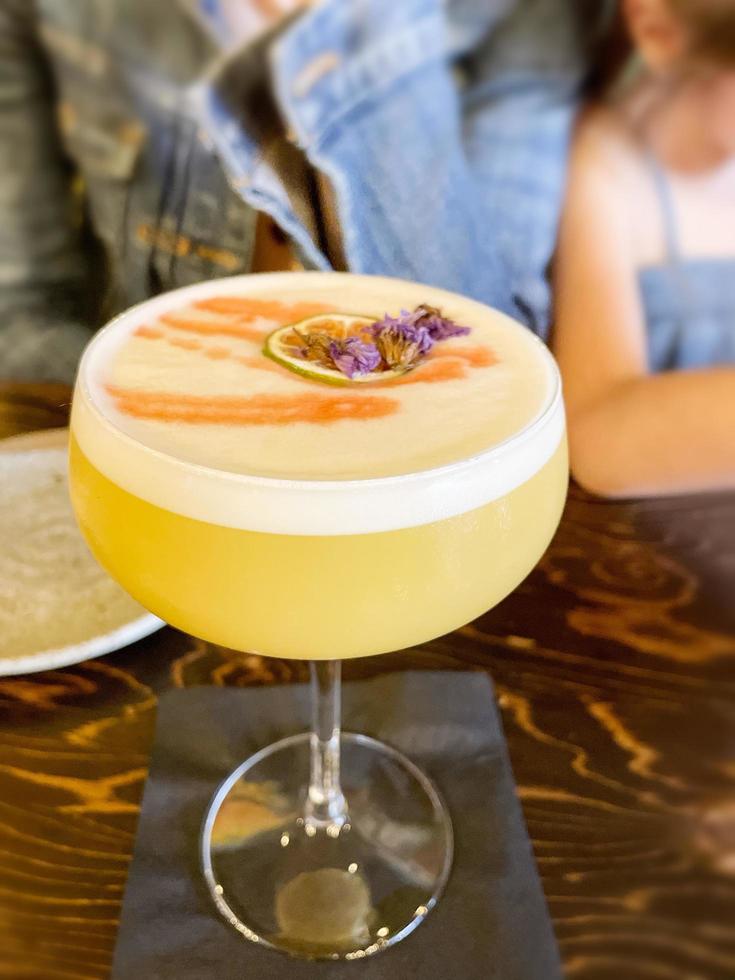 Orange flavored drink with a flower at a bar photo