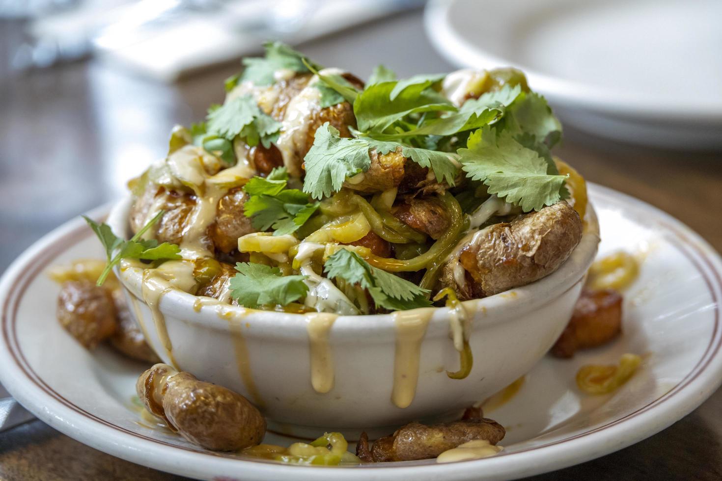 Batatas Bravas with peppers and parsley at a restaurant photo