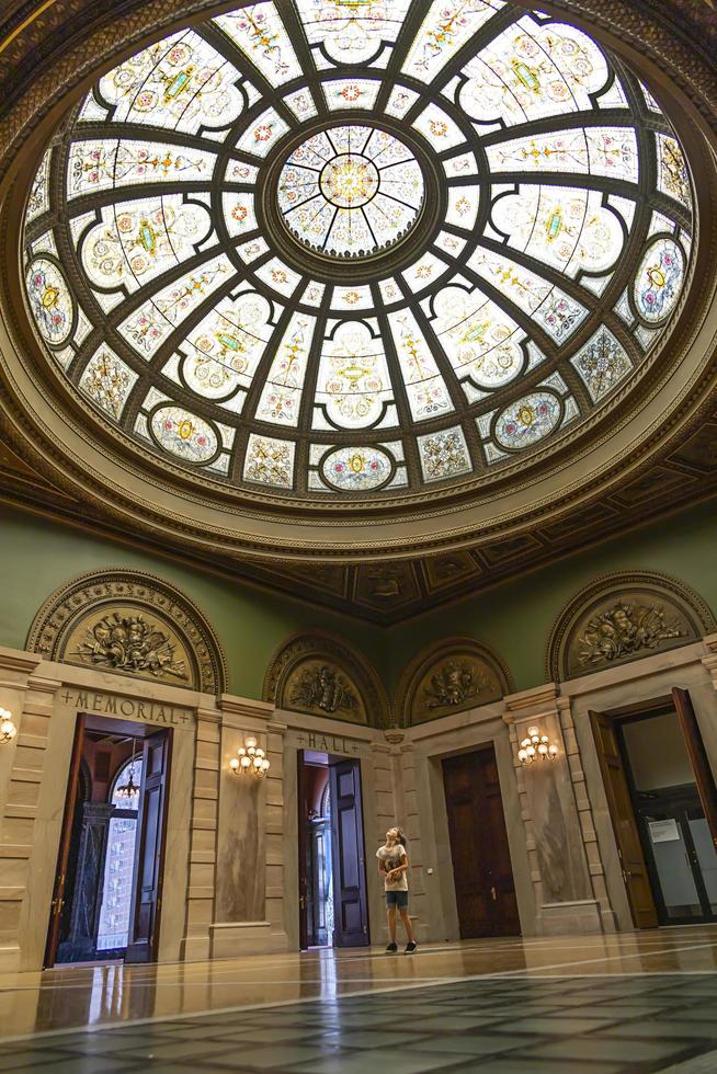 Little girl looking up at a glass dome window in a museum photo