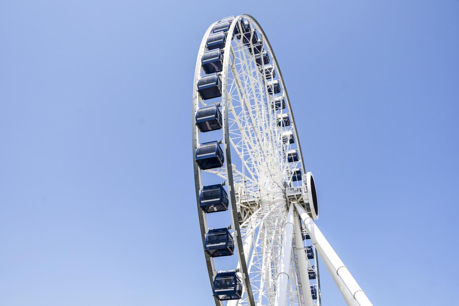 White and Black Ferris wheel in from of blue sky with clouds photo