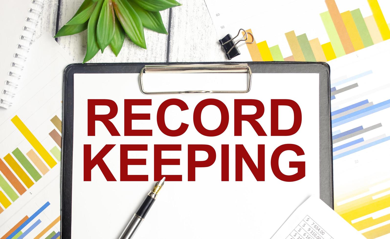 RECORD KEEPING text written on paper folder and charts photo