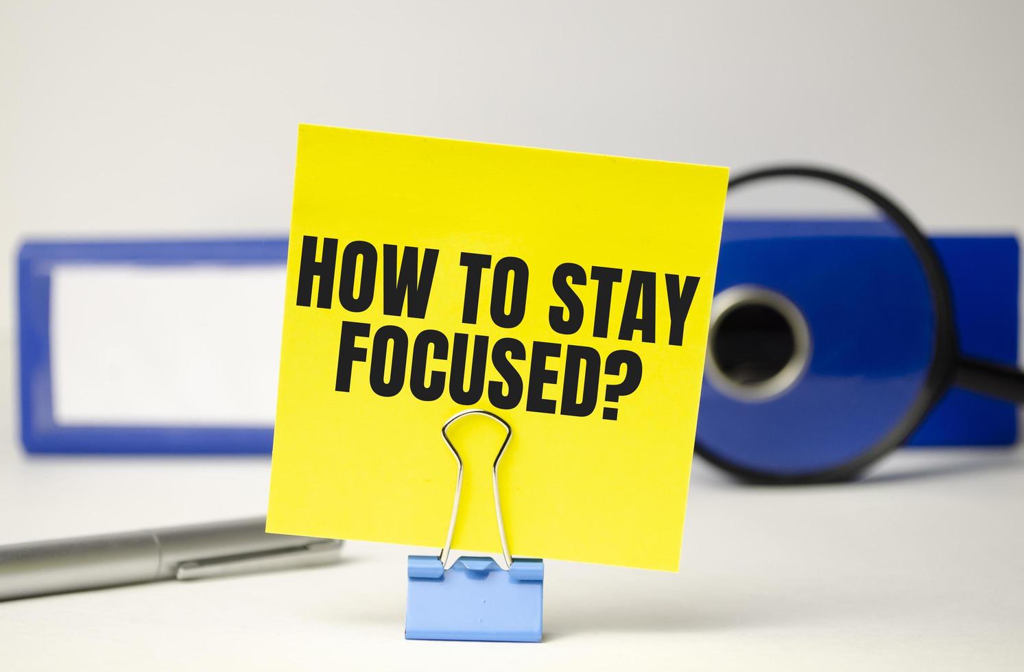 word how to stay focused on yellow sticker and blue folder photo