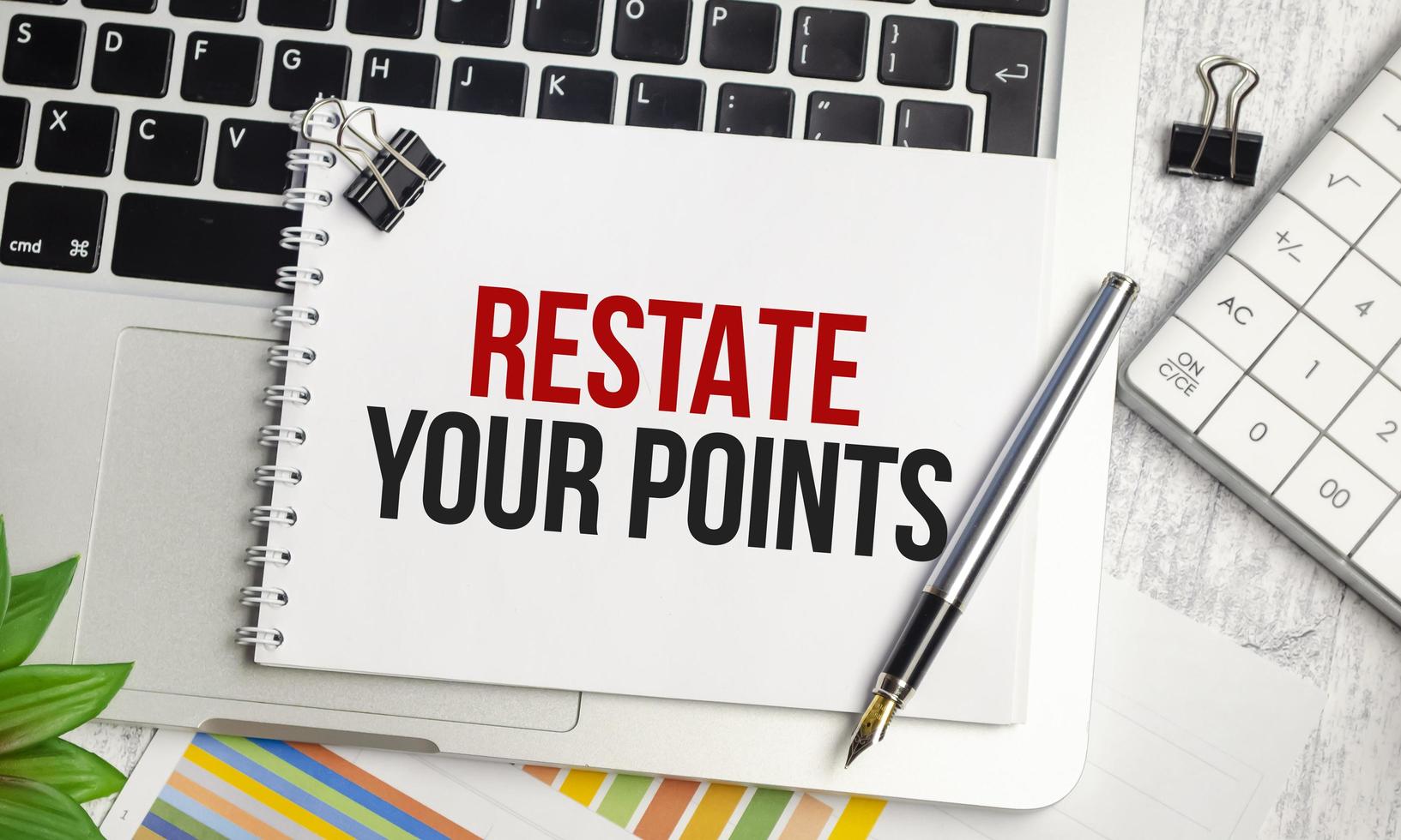 RESTATE YOUR POINTS text and notepad with pen, charts and calculator photo