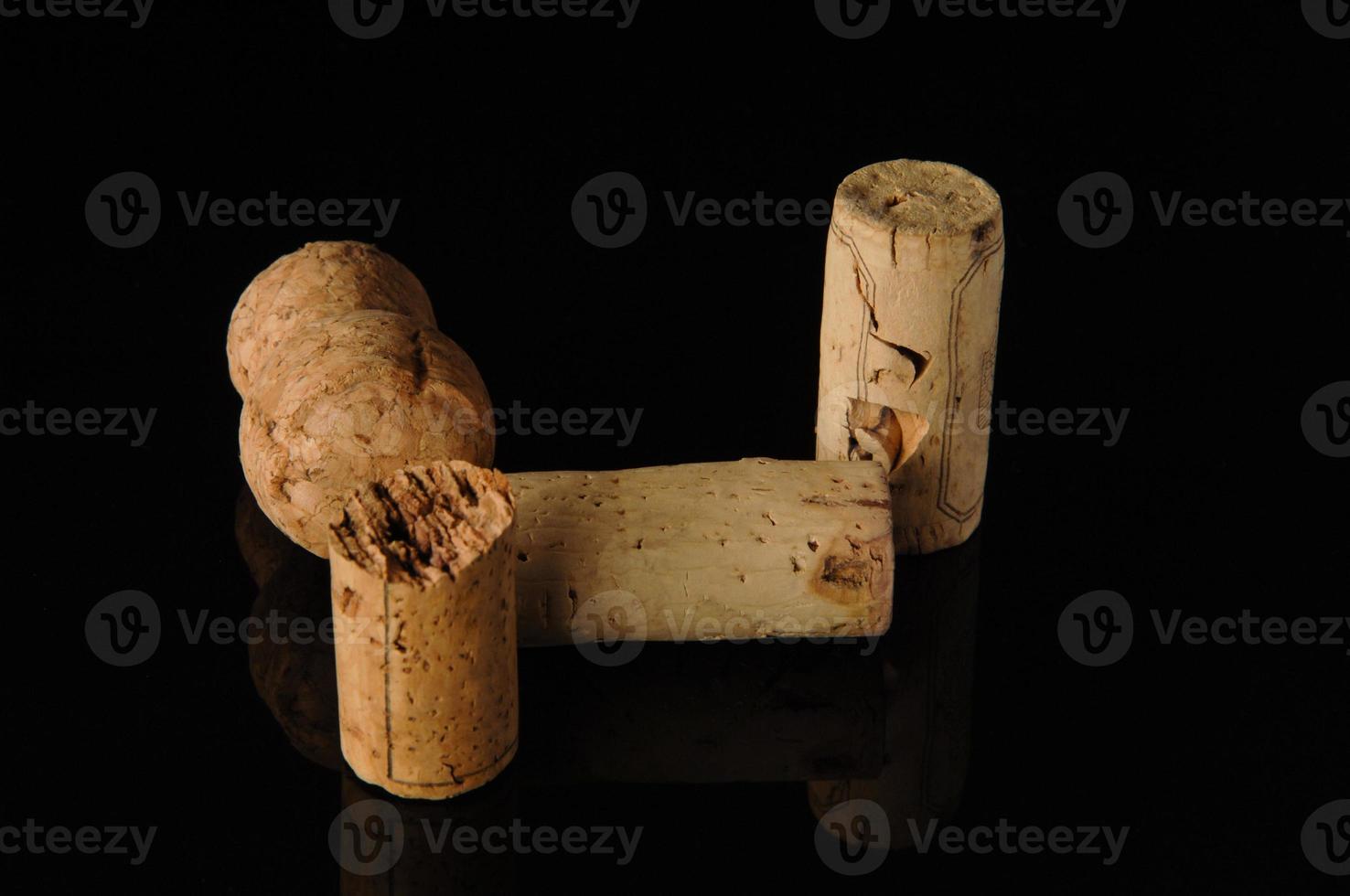 A close-up shot of some wine corks on a reflecting surface. photo