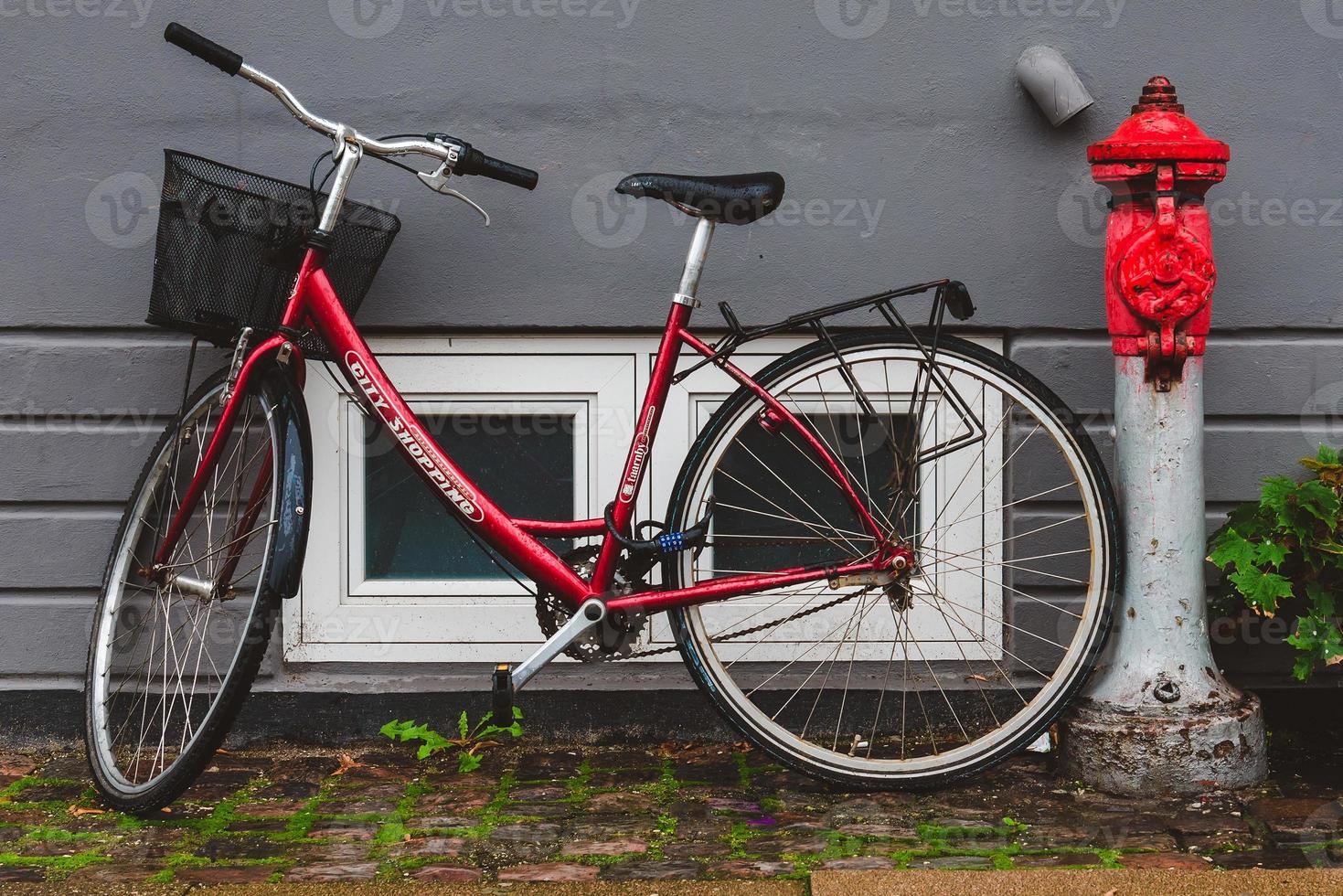 bicicleta roja con balde cerca de la bomba contra incendios foto