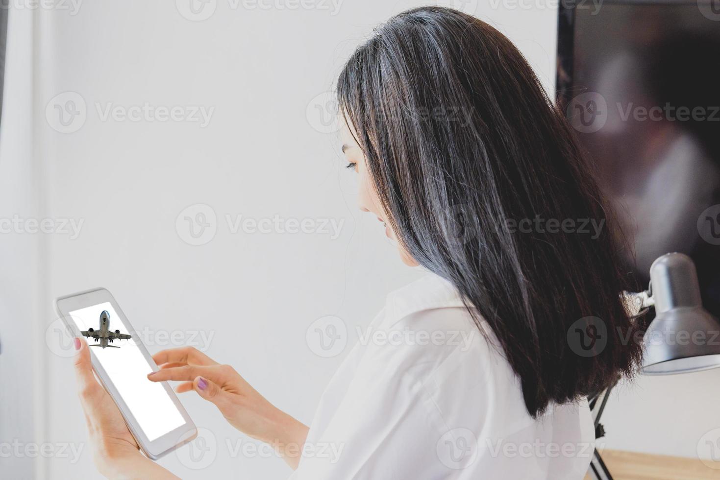 Young Woman Buying Air Tickets Online On Tablet Computer photo