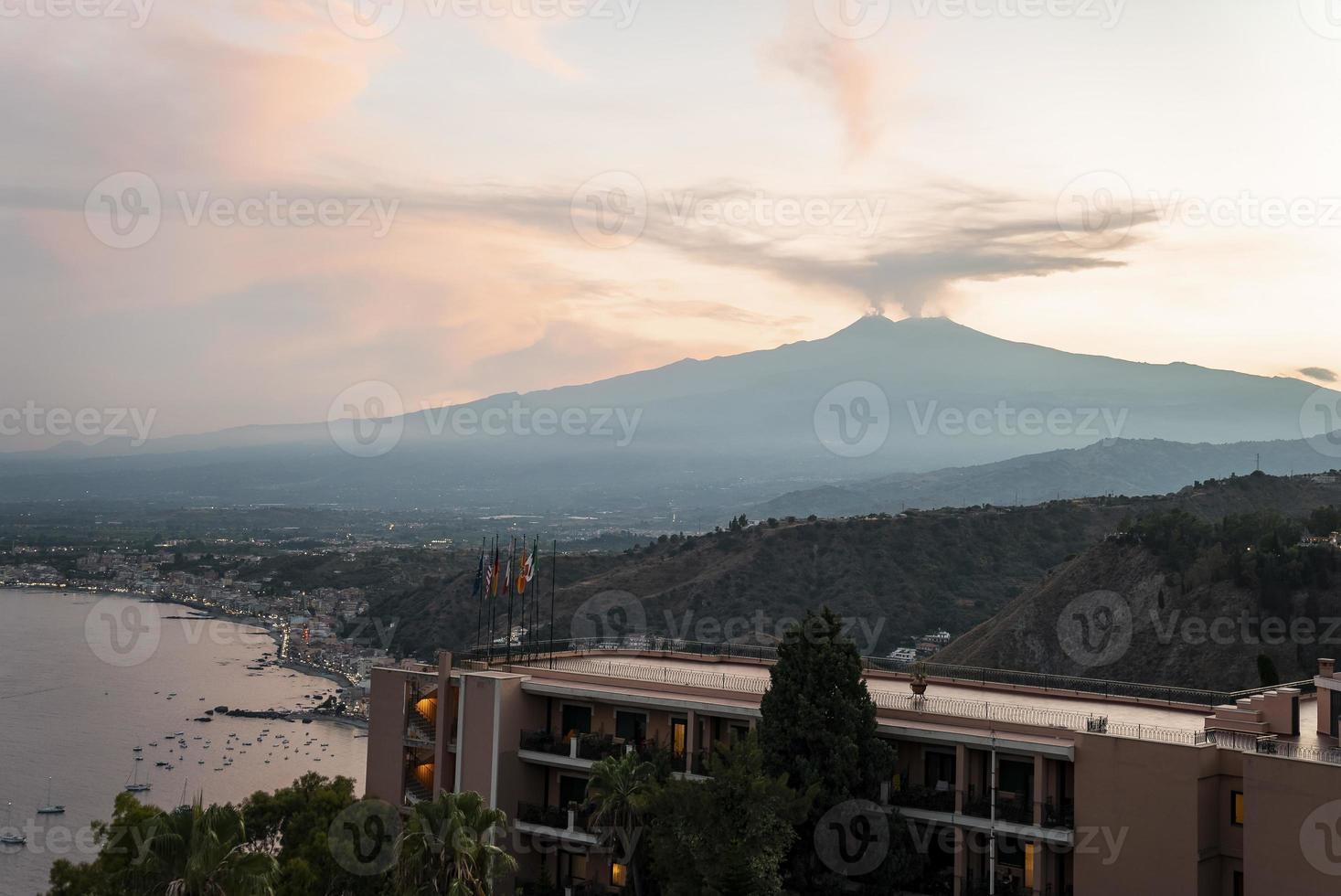 View of Hotel Elios overlooking volcanic Mount Etna with sky in background photo